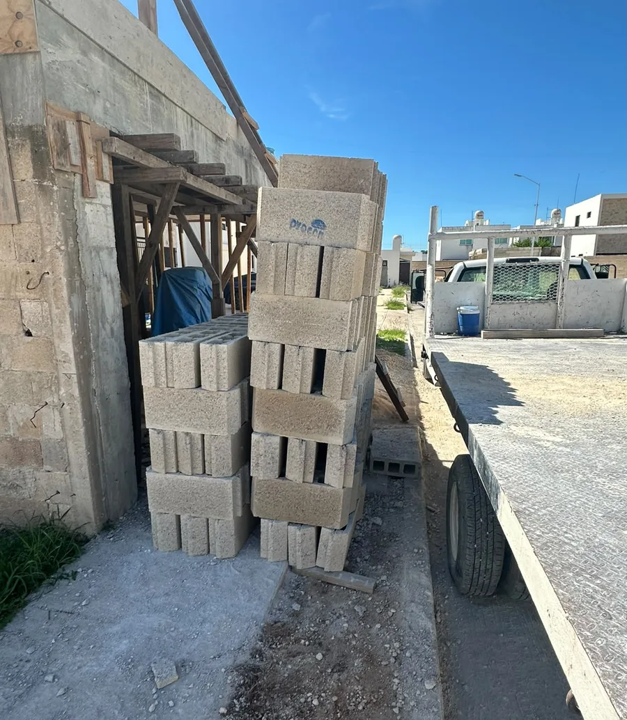 Block apilado junto a una obra y camión de reparto